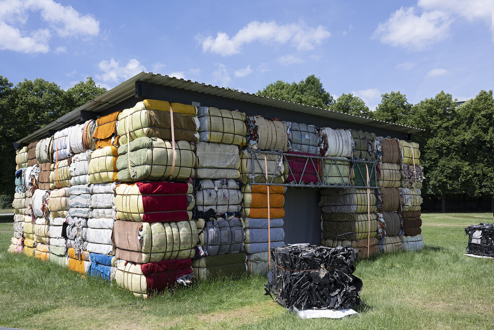The Nest Collective, Return To Sender, 2022. Provisional structure composed of used garments fashioned into bales, dimensions variable. Image courtesy of Documenta 15, Kassel. Photo by Nils Klinger.